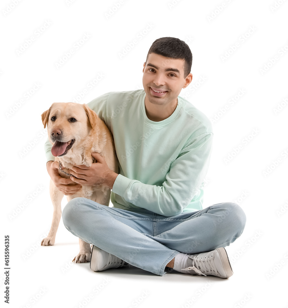 Young man with cute Labrador dog sitting on white background