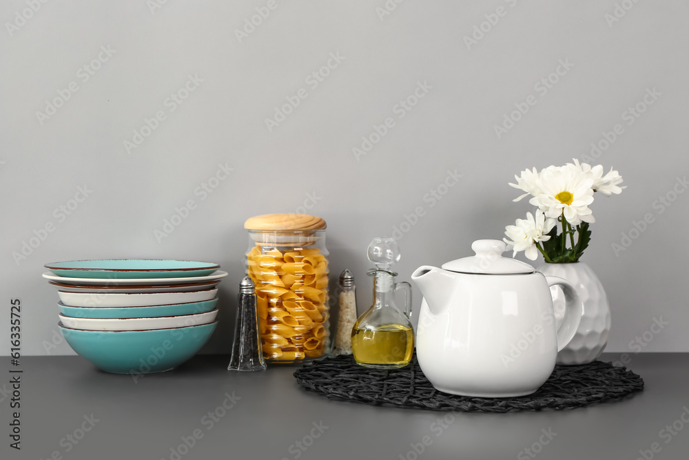 Composition with teapot and different kitchen stuff on black table