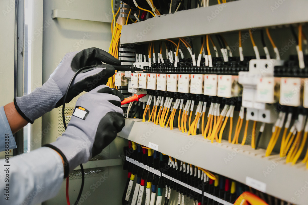 Electrical engineers test electrical installations and wiring on protective relays, measuring them w