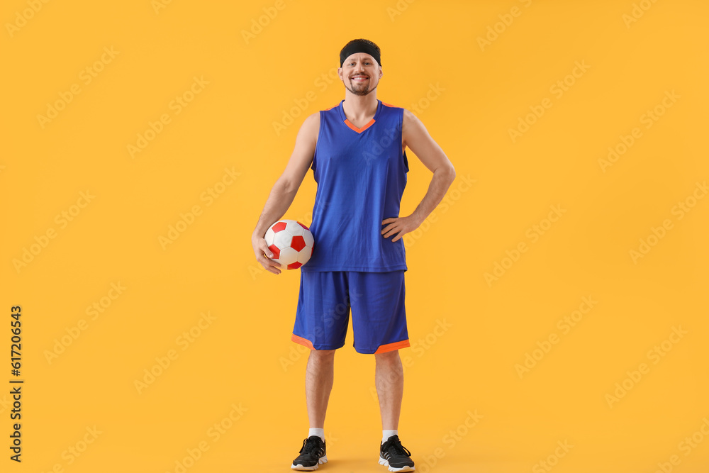 Soccer player with ball on yellow background