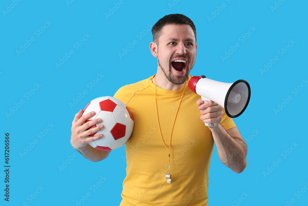Male coach with soccer ball and megaphone on blue background