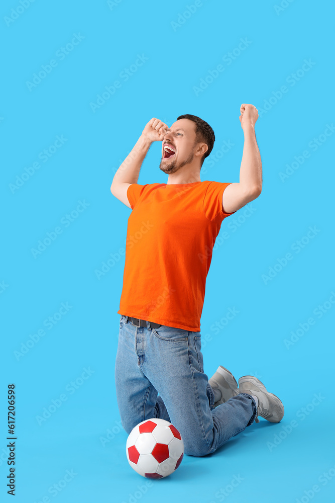 Happy man with soccer ball on blue background