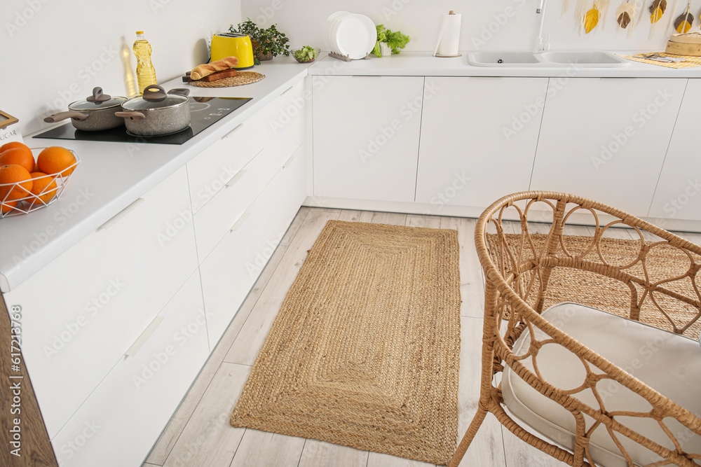 Stylish wicker rug in interior of modern kitchen