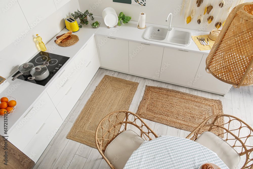 Stylish wicker rugs in interior of modern kitchen