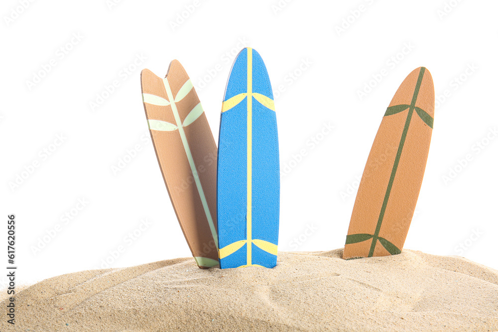 Mini surfboards on sand against white background