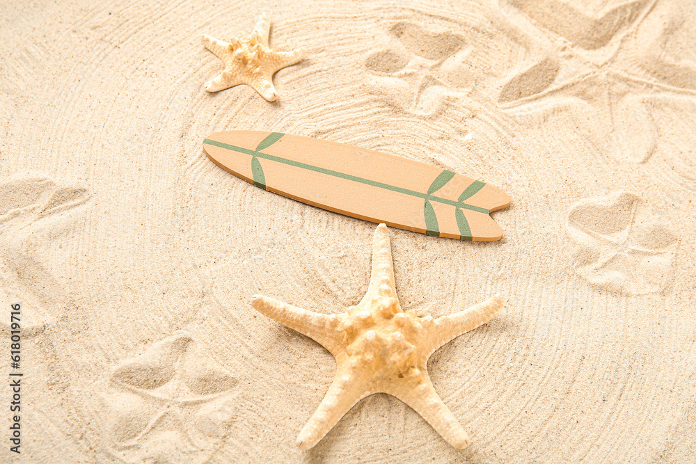 Mini surfboard with starfish on sand