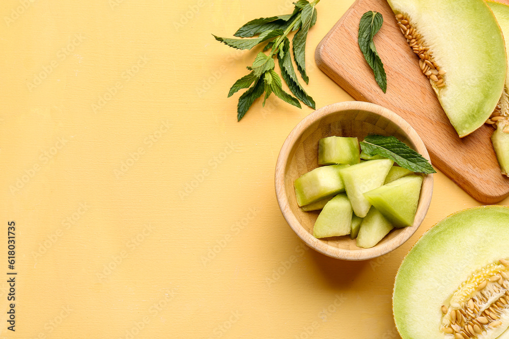 Bowl and board with pieces of sweet melon on yellow background