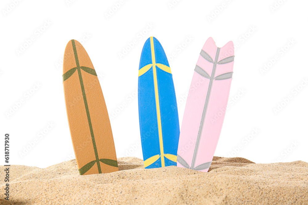 Different colorful mini surfboards on sand against white background