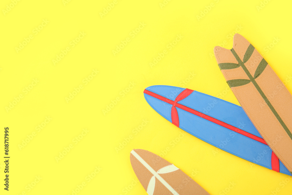 Mini different colorful surfboards on yellow background