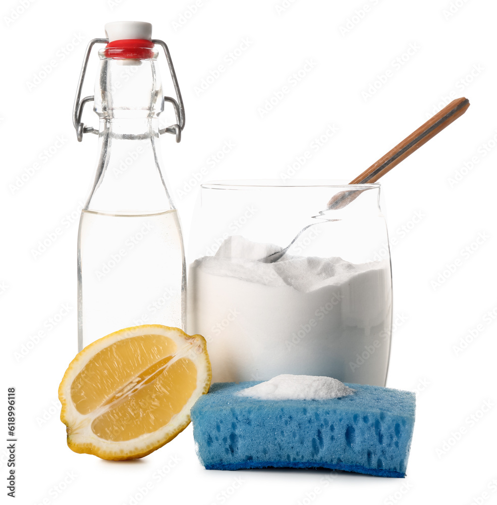 Jar with baking soda, bottle of vinegar, cleaning sponge and lemon on white background