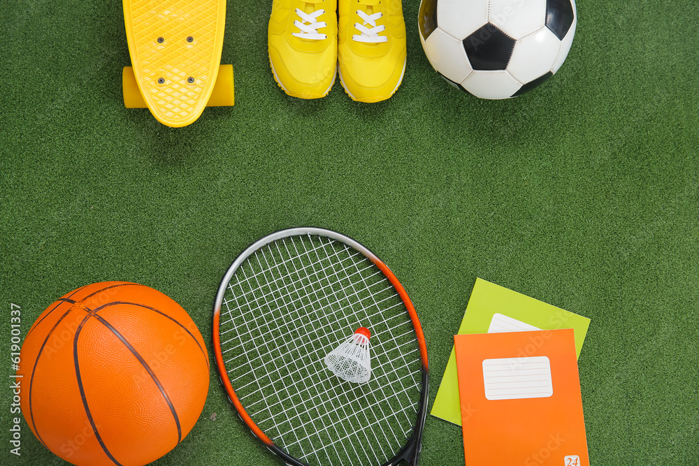 Sport equipment with sneakers and notebooks on color background