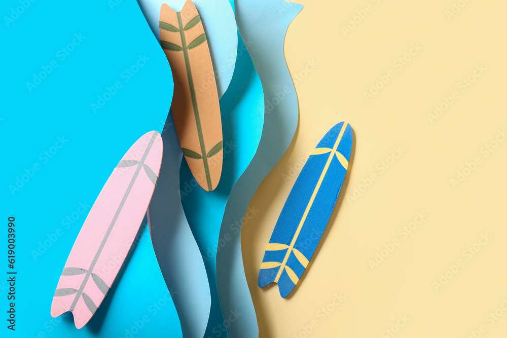 Creative composition with mini surfboards and paper waves on pale yellow background