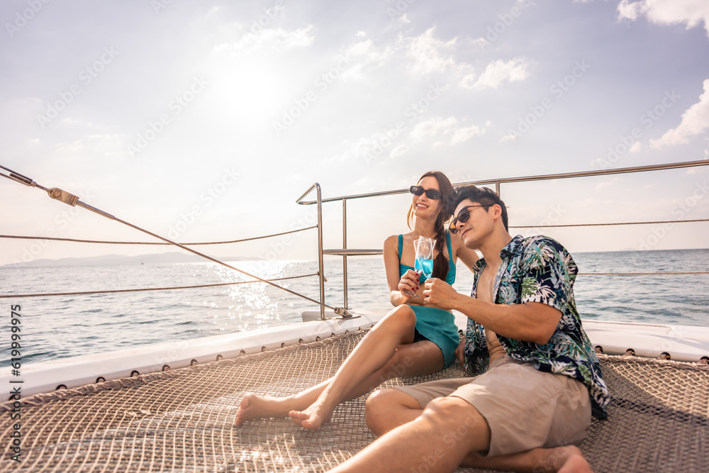 Asian beautiful couple drinking champagne while having party in yacht