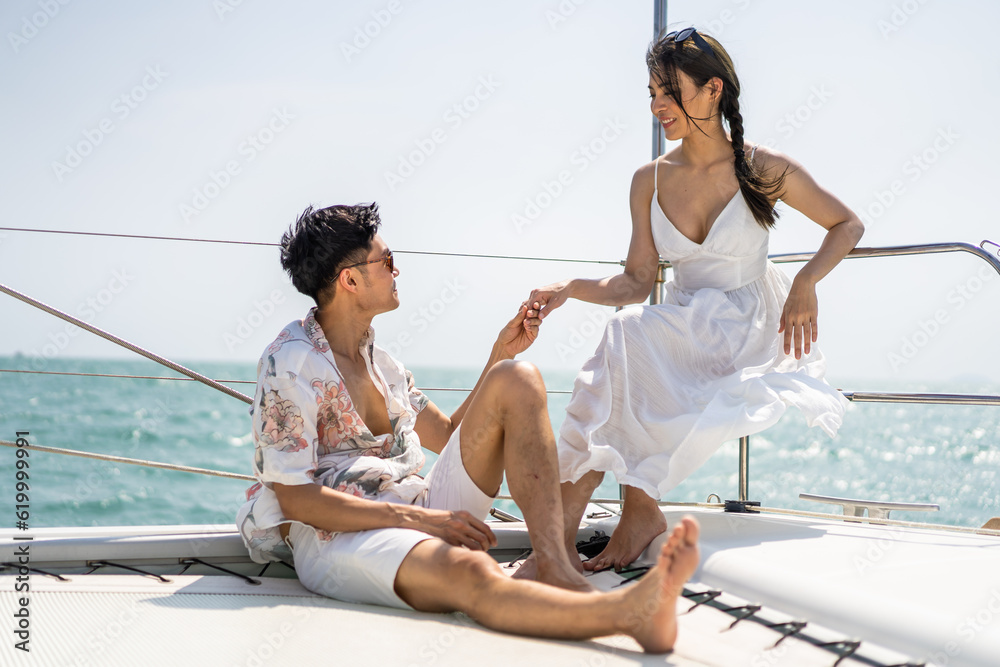 Asian young romantic couple looking at beautiful view during yachting. 