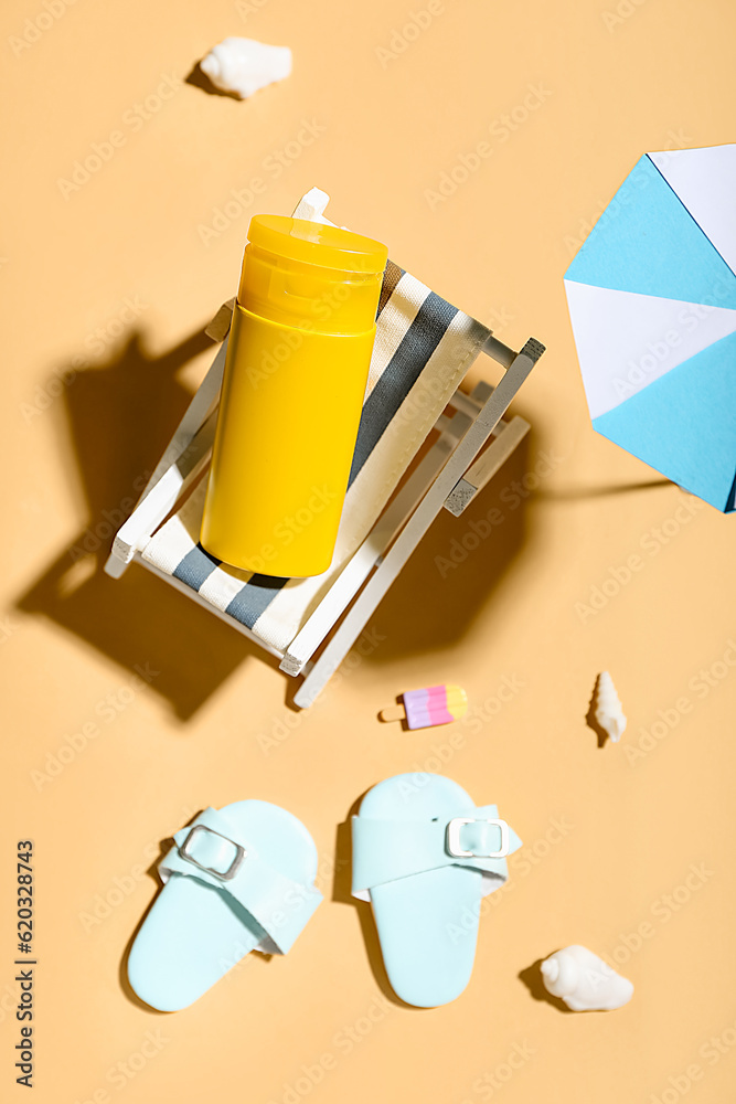 Creative composition with miniature deckchair, umbrella and sunscreen on color background