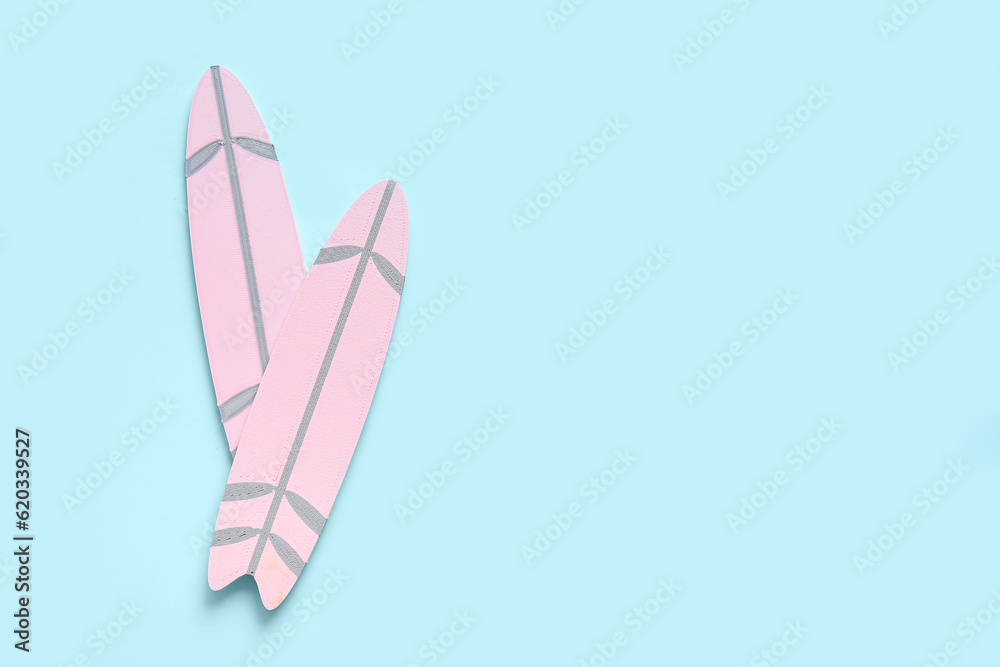 Mini pink surfboards on blue background