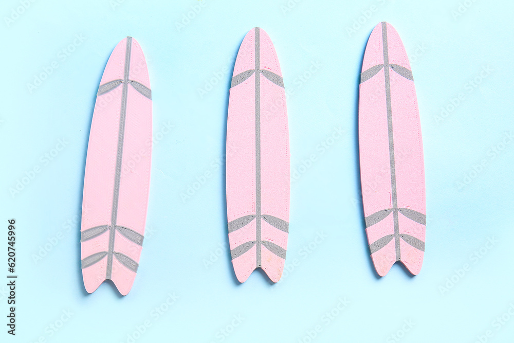 Mini pink surfboards on blue background