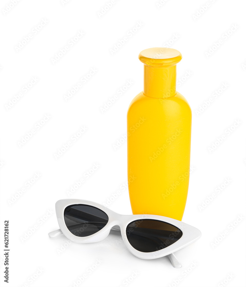 Sunglasses with bottle of sunscreen cream isolated on white background