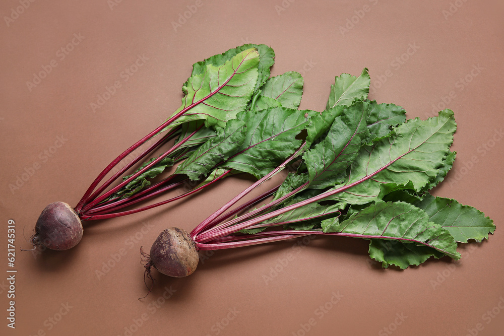 Fresh beetroots with leaves on brown background