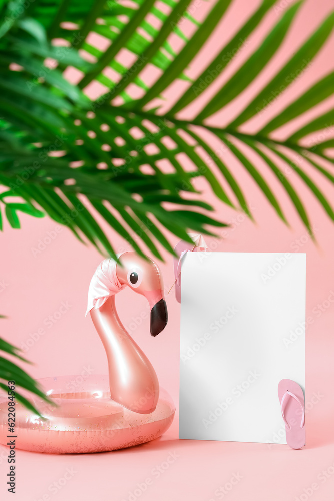 Blank poster with inflatable ring in shape of flamingo and plant leaves on pink background. Travel c