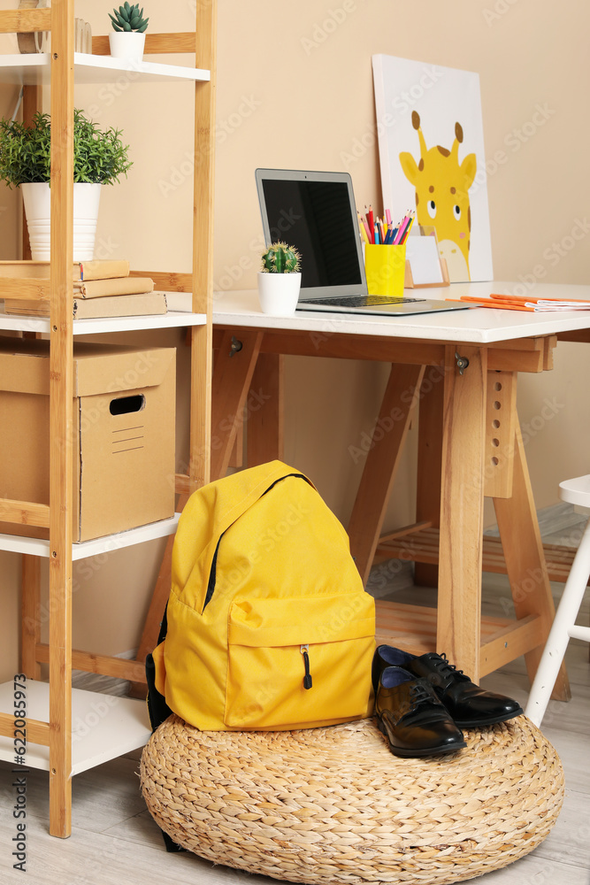 Stylish interior of childrens room with school backpack and shoes, closeup