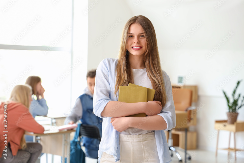Female student with books in classroom