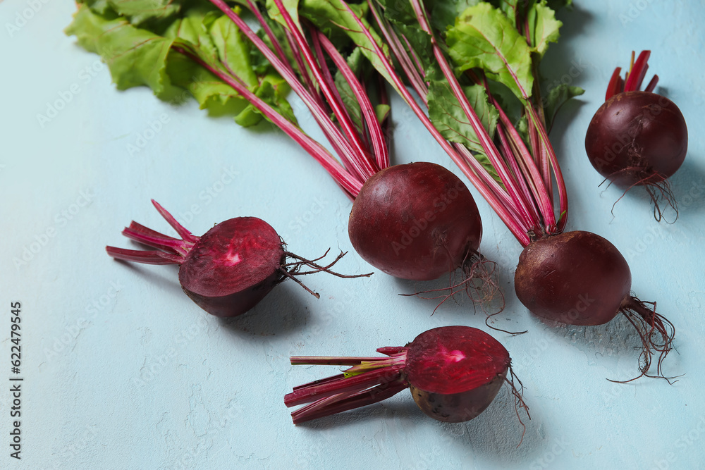 Fresh beets with green leaves on blue background