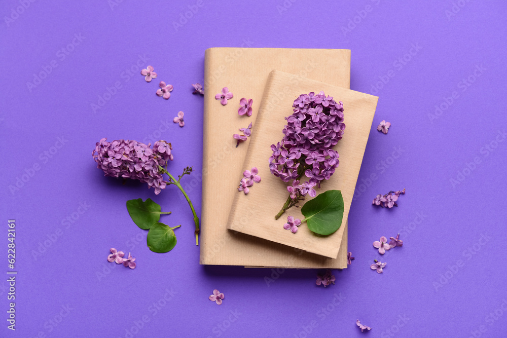 Beautiful lilac flowers and books on purple background