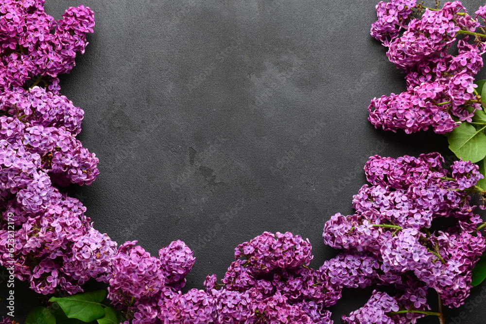 Frame made of beautiful bright lilac flowers on dark background