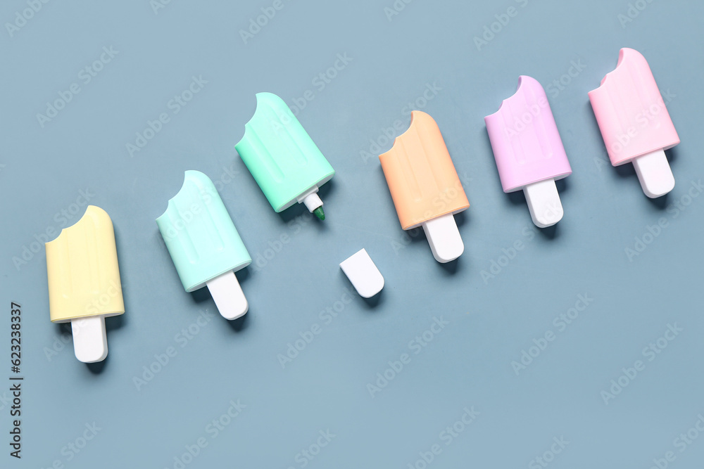 Colorful markers in shape of ice cream on grey background