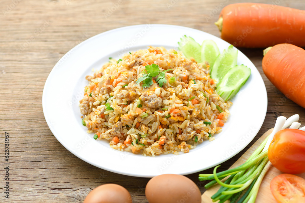 Fried rice with pork and egg  on wooden table.