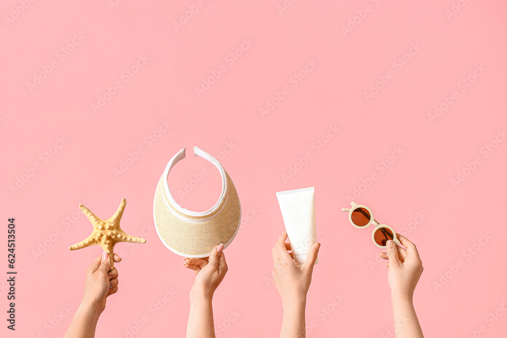 Many hands with beach accessories on pink background