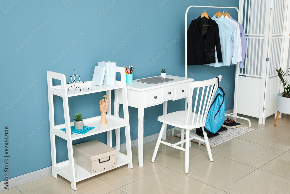 Stylish interior of childrens room with laptop and school uniform