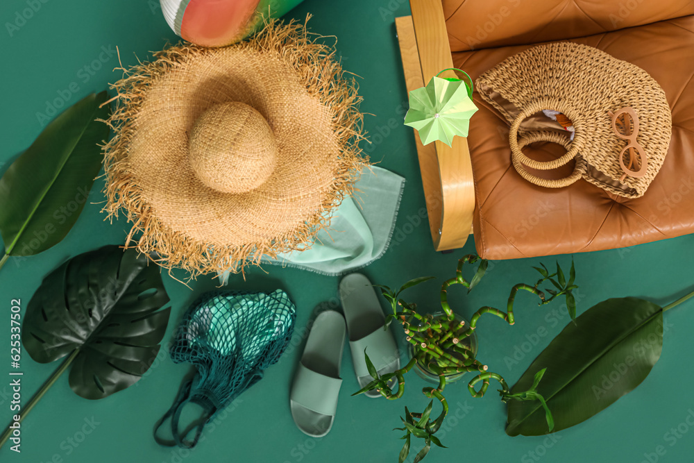 Composition with beach accessories and palm leaves on green background