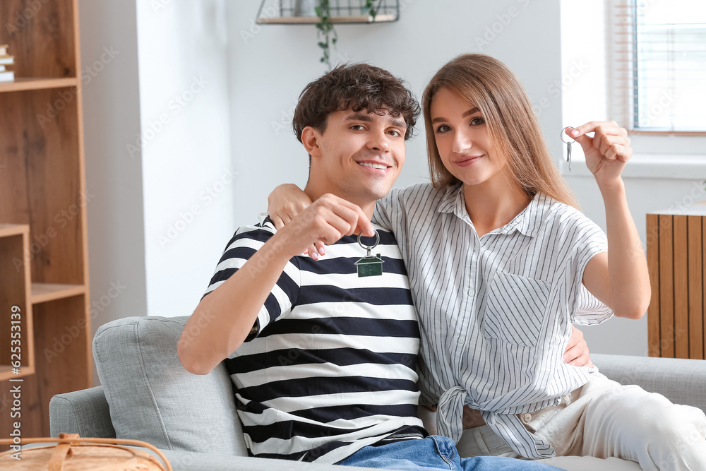 Young couple with keys in their new flat
