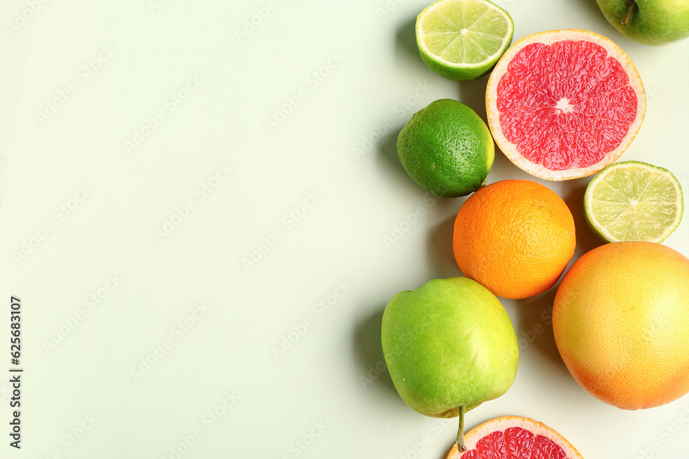 Different fresh fruits on green background