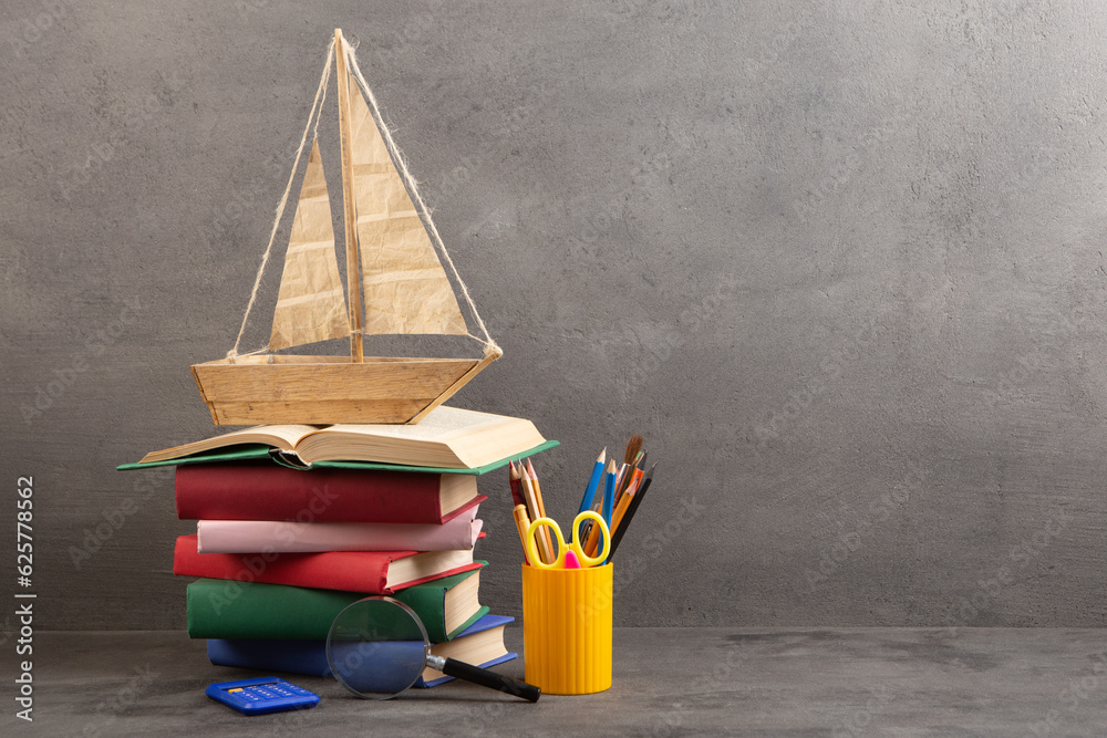 Education is a journey concept, toy boat and books on the table, inspiration for a writing a fairy t