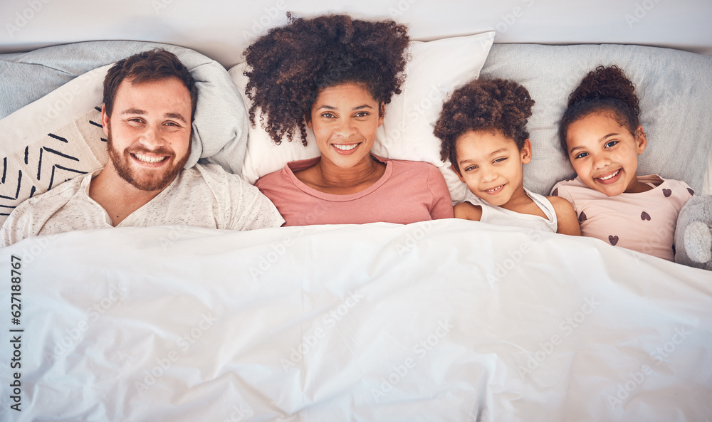 Family, happy and portrait in bed at home for quality time, bonding or morning routine. Above, mixed