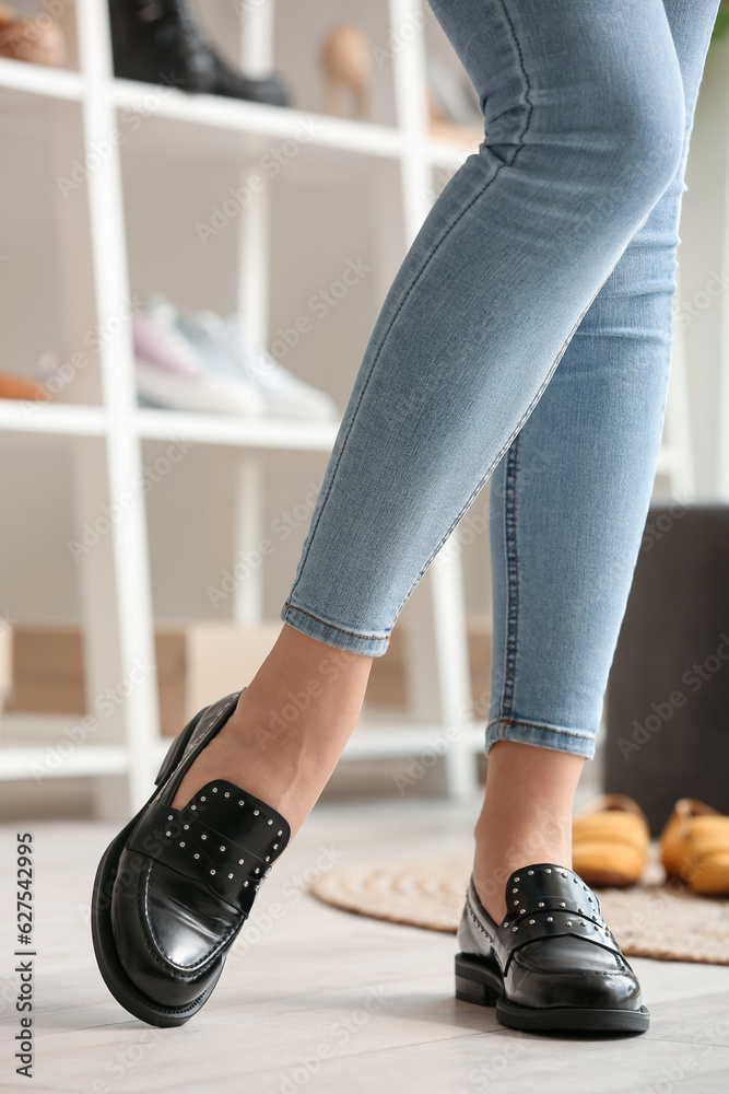 Woman trying on stylish black shoes in boutique, closeup