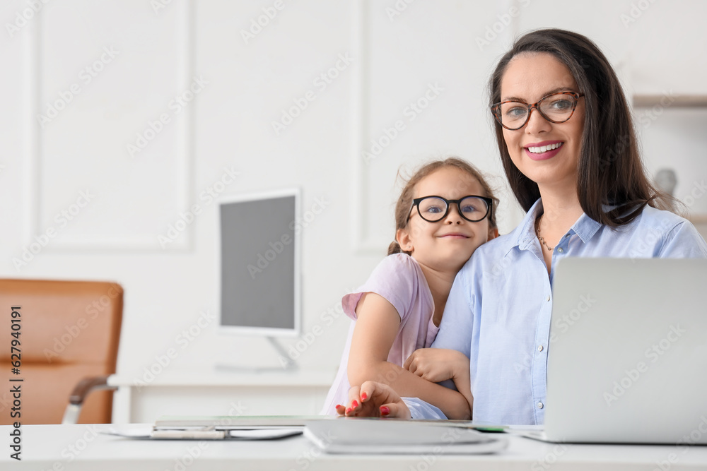 Little girl hugging her working mother in office