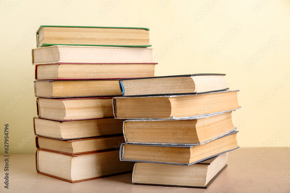 Stacks of books on beige table