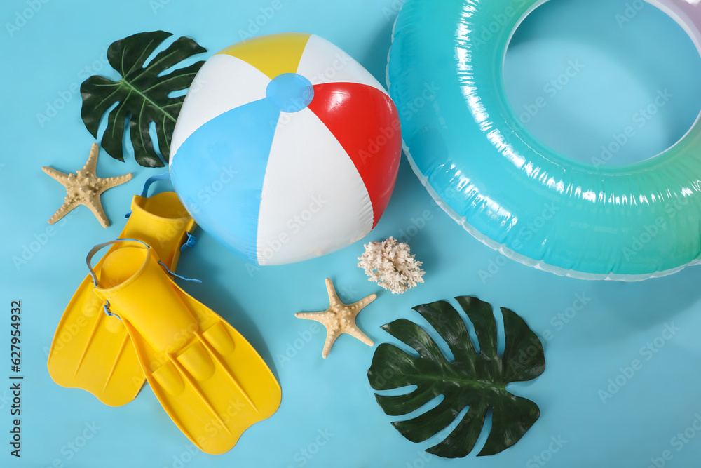 Inflatable ring with beach accessories on blue background