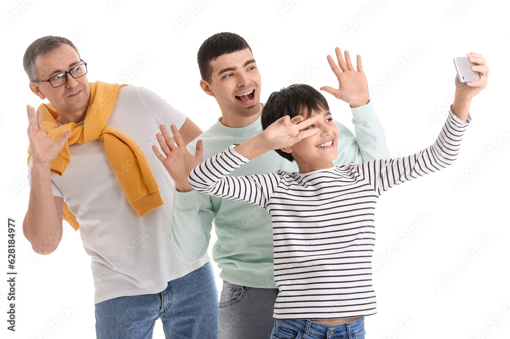 Happy little boy with his dad and grandfather taking selfie on white background
