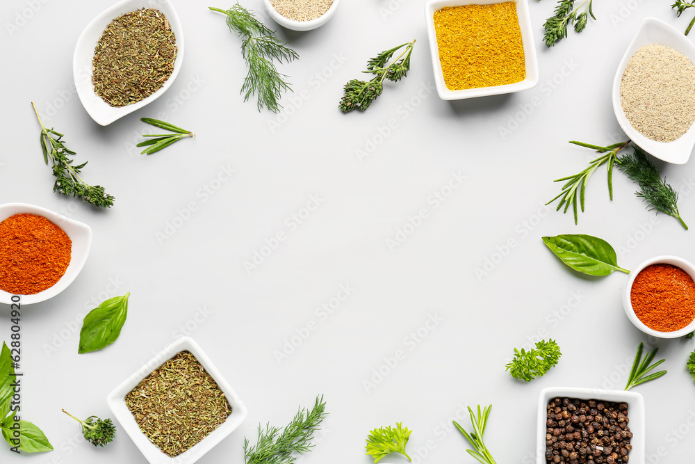 Frame made of different spices and herbs on light background
