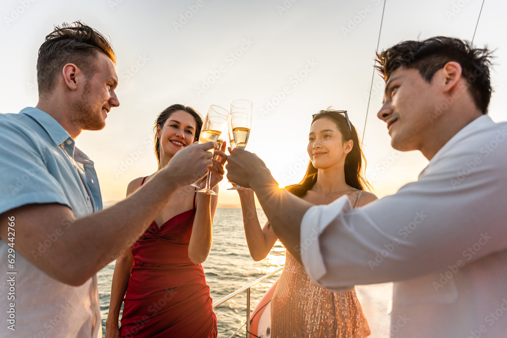 Group of diverse friends drink champagne while having a party in yacht. 