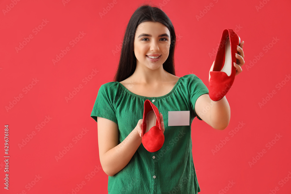 Female seller with stylish shoes on red background