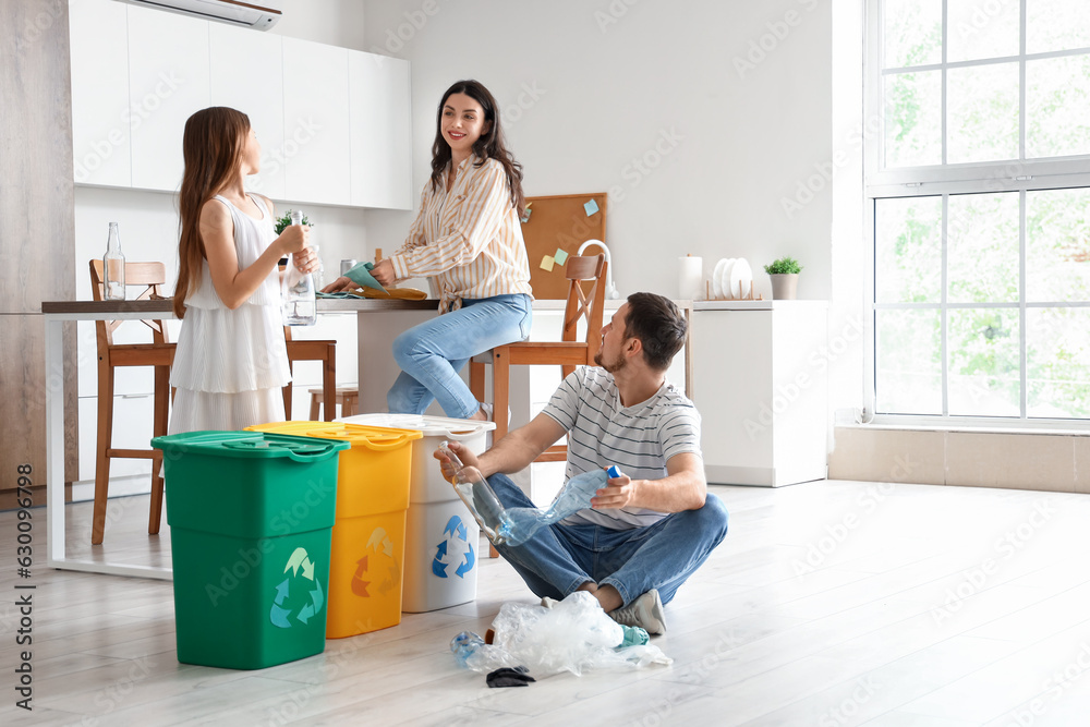 Family sorting garbage with recycle bins in kitchen