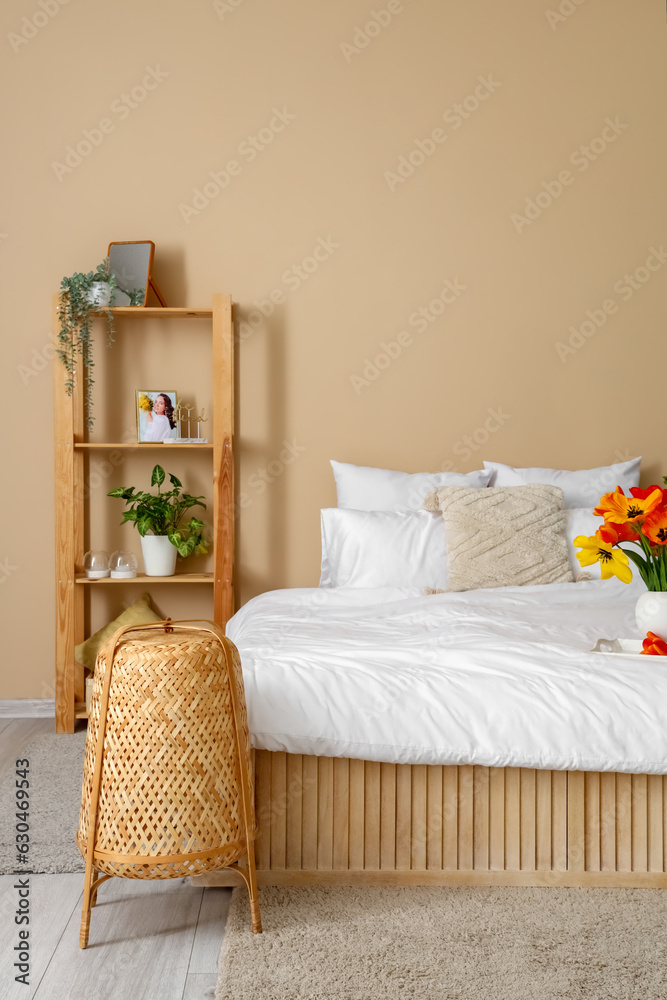 Interior of stylish living room with tulip flowers in vase on bed