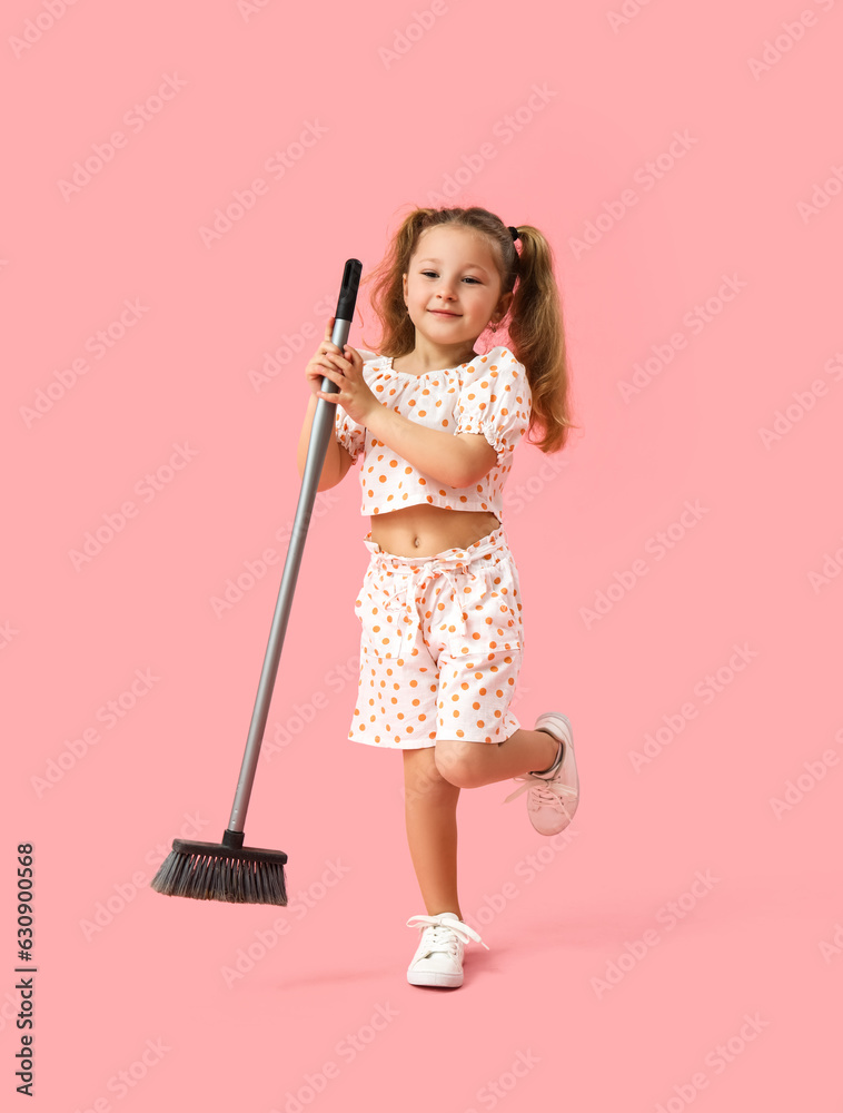 Cute little girl with broom on pink background