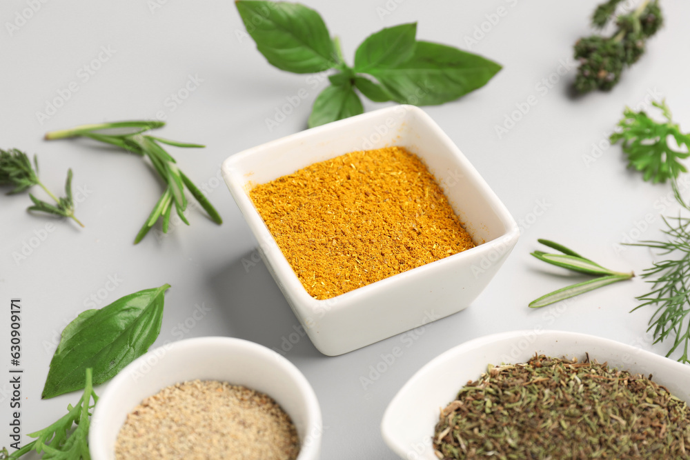 Composition with different herbs and spices on light background, closeup